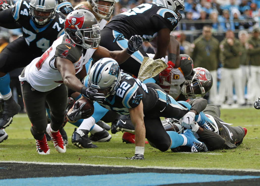 Carolina Panthers' Christian McCaffrey (22) runs for a touchdown as Tampa Bay Buccaneers' Adarius Taylor (53) defends in the first half of an NFL football game in Charlotte, N.C., Sunday, Nov. 4, ...