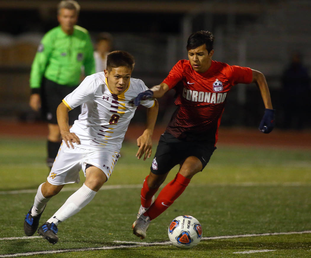 Elderado's Roberto Gonzalez (8) runs with the ball while being covered by Coronado's Moctezuma Maldonado (5) during the state quarterfinal game at Faith Lutheran High School in Las Vegas, Thursday ...