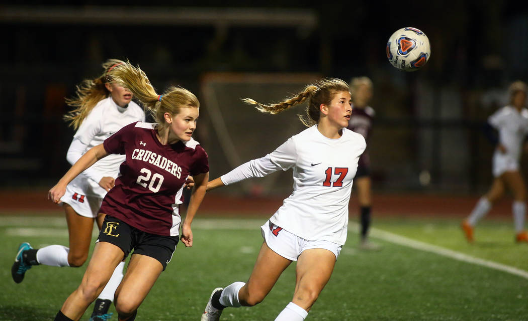 Corando's Emily Wickens (17) runs towards the ball while being covered by Faith Lutheran's McManns (20) during the state quarterfinal game at Faith Lutheran High School in Las Vegas, Thursday, Nov ...