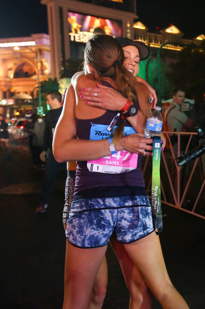 First place women's finisher Hannah McInturff hugs second place women's finisher Jessica Sams after she crosses the finish line during the 2018 Rock 'n' Roll Marathon on the Strip in Las Vegas, Su ...