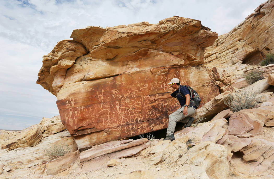 Jose Witt, southern Nevada director of Friends of Nevada Wilderness, points out petroglyphs while leading a hike Sunday in Gold Butte. Photo by Ronda Churchill for The Washington Post