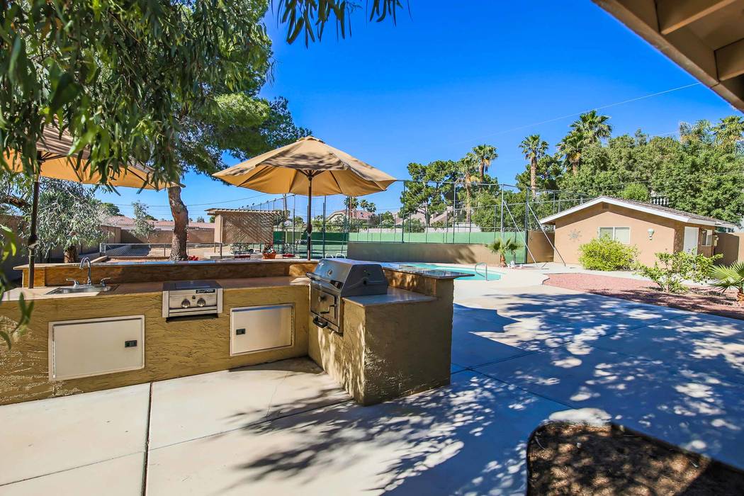 The outdoor kitchen is near the pool and tennis court. (Xpand Realty)