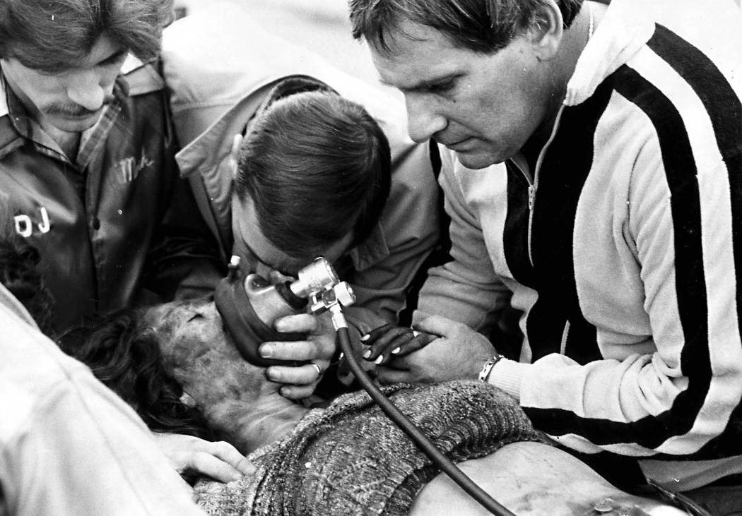 Fighting for life: An unidentified husband grieves over his wife who was burned Friday, Nov. 21, 1980, in a monumental fire at the MGM Grand Hotel. The woman, who survived the fire was taken to a ...