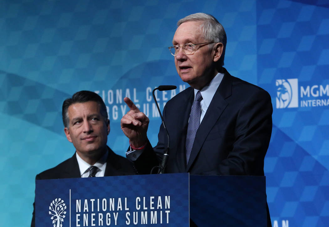 Former U.S. Sen. Harry Reid, D-Nev., speaks as Gov. Brian Sandoval looks on during the National Clean Energy Summit Friday, Oct. 13, 2017, in Las Vegas. Bizuayehu Tesfaye Las Vegas Review-Journal ...