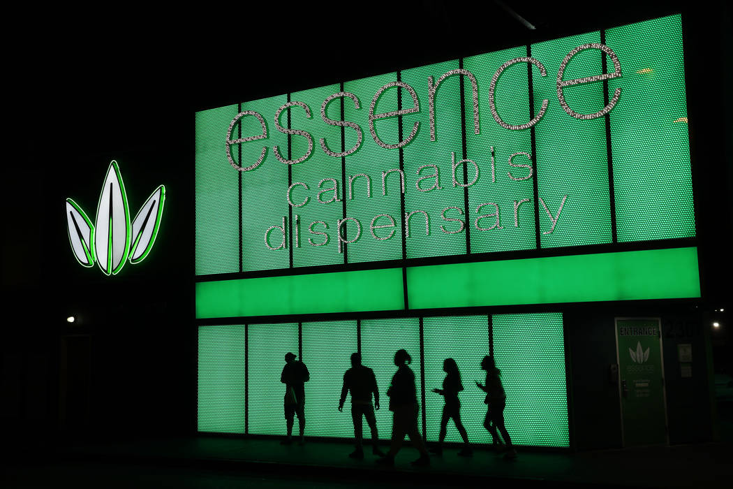 In this April 16, 2018, file photo, people stand outside after shopping at the Essence cannabis dispensary in Las Vegas. (AP Photo/John Locher)