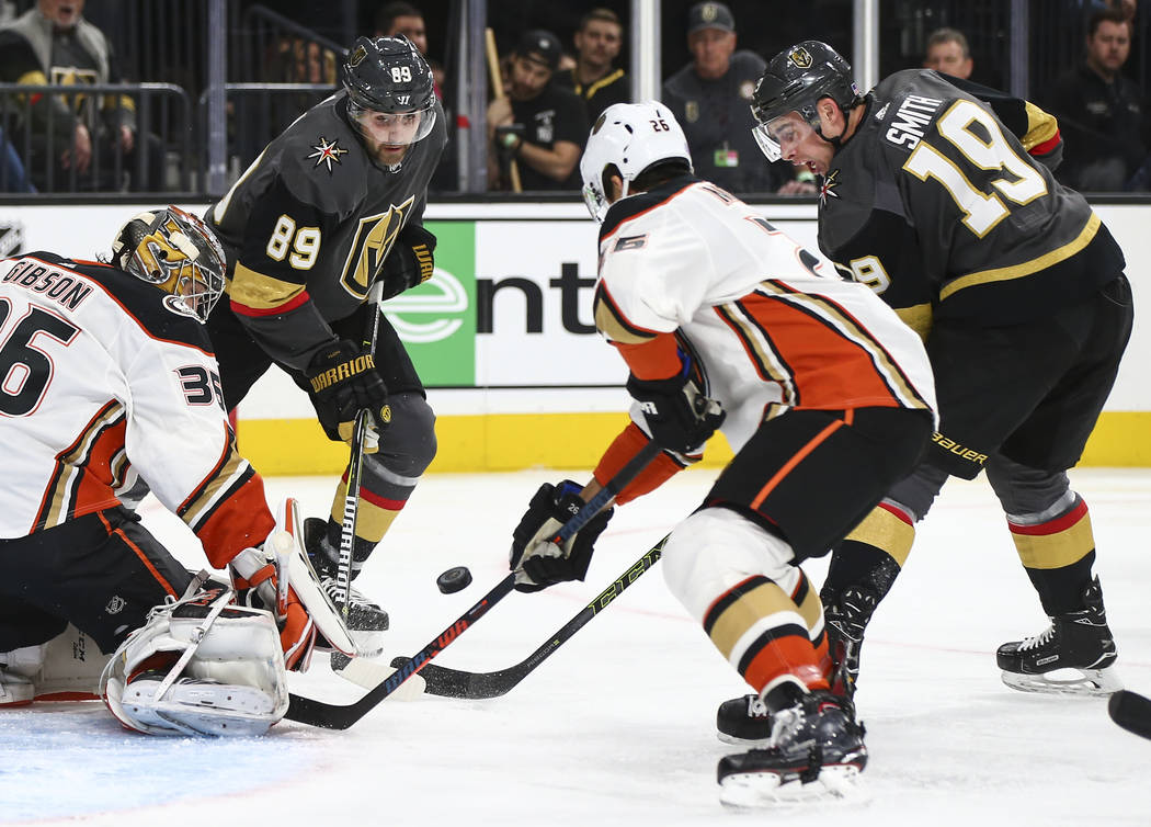 Golden Knights forwards Alex Tuch (89) and Reilly Smith (19) try to get the puck in against Anaheim Ducks goaltender John Gibson (36) and defenseman Brandon Montour (26) during the first period of ...