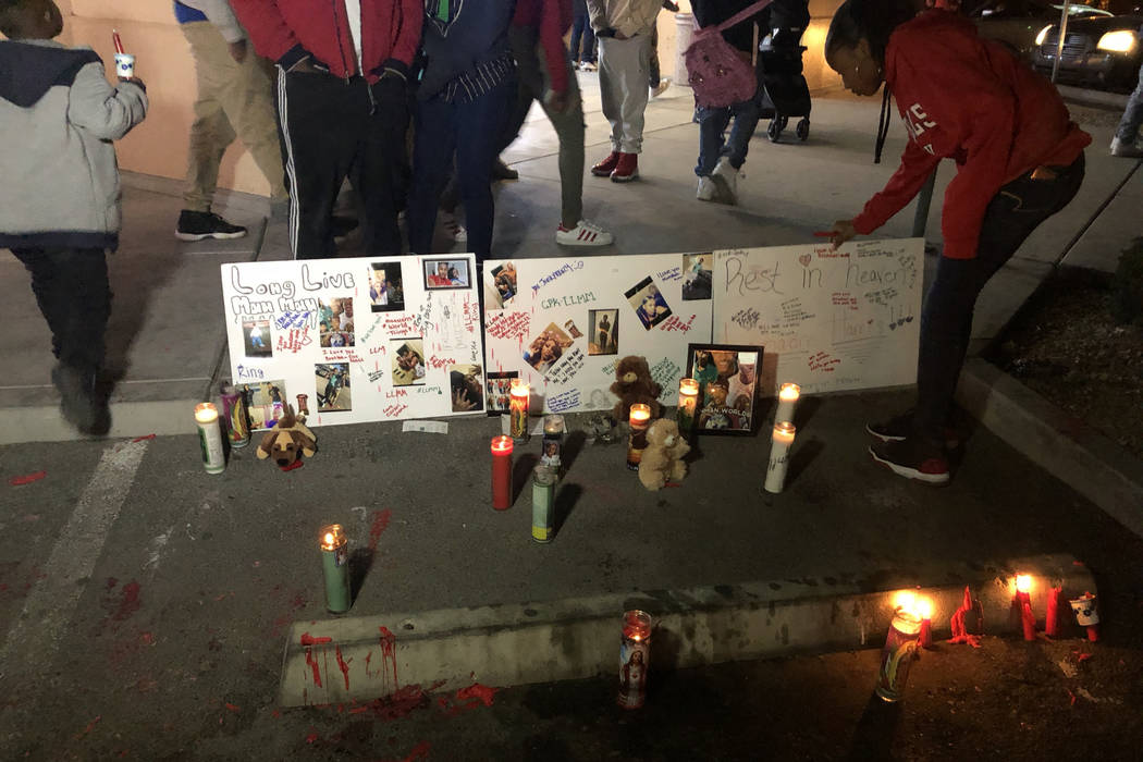 A woman adjusts posters remembering LaMadre Harris during a vigil Wednesday night. The 16-year-old boy died after a shooting in North Las Vegas on Tuesday, Nov. 13, 2018, his mother said. (Katelyn ...