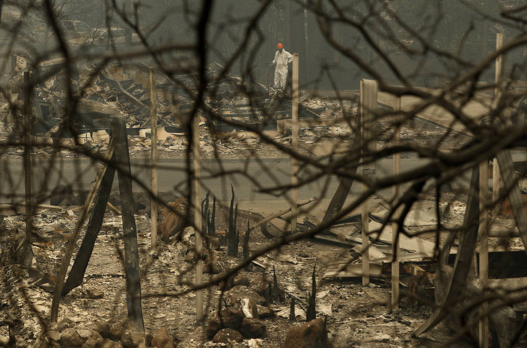 A search and rescue worker searches for human remains at a burned out trailer park from the Camp Fire, Tuesday, Nov. 13, 2018, in Paradise, Calif. The deadliest, most destructive blaze in Californ ...