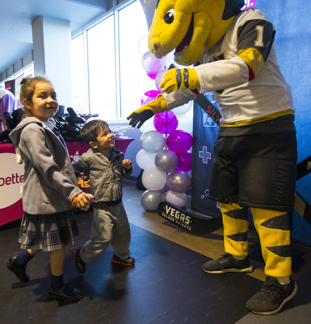 Bailey Detmer, 5, with her brother Michael, 3, greet Golden Knights mascot Chance during the second annual "Silver and Gold" food drive at City National Arena in Las Vegas on Thursday, N ...