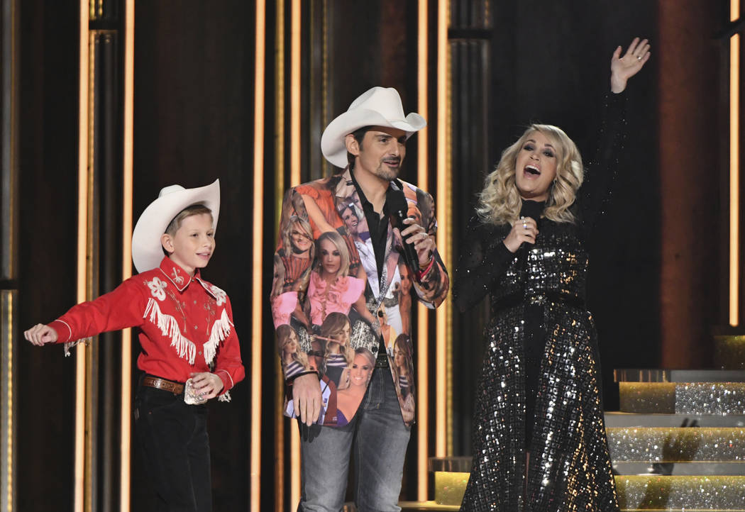 Mason Ramsey, left, "Floss" dances as hosts Brad Paisley, center, and Carrie Underwood look on at the 52nd annual CMA Awards at Bridgestone Arena on Wednesday, Nov. 14, 2018, in Nashvill ...