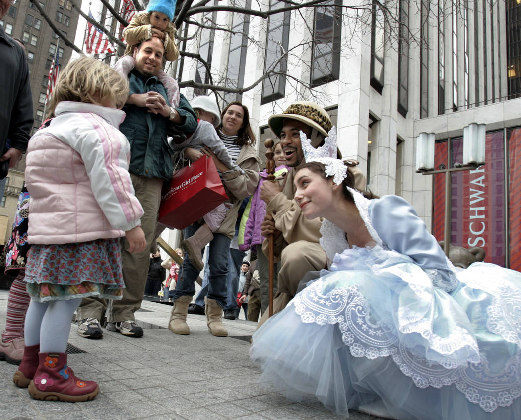 FILE - In this Nov. 22, 2004 file photo, children are greeted by characters from FAO Schwarz outside the store on New York's Fifth Avenue. Three years after it closed its beloved toy store on Fift ...