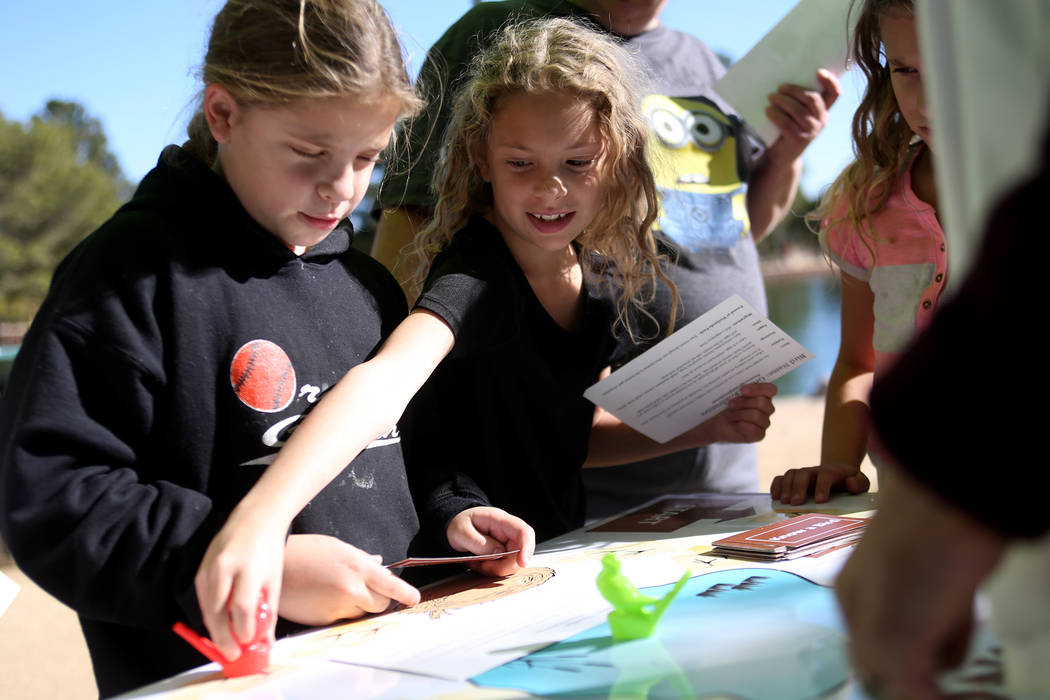 Jayden Hallmark, 9, from left, and her triplet sister Jenna Hallmark, 9, play a game to learn about birds at Migratory Bird Day at Sunset Park in Las Vegas, Sunday, Nov. 18, 2018. Different organi ...