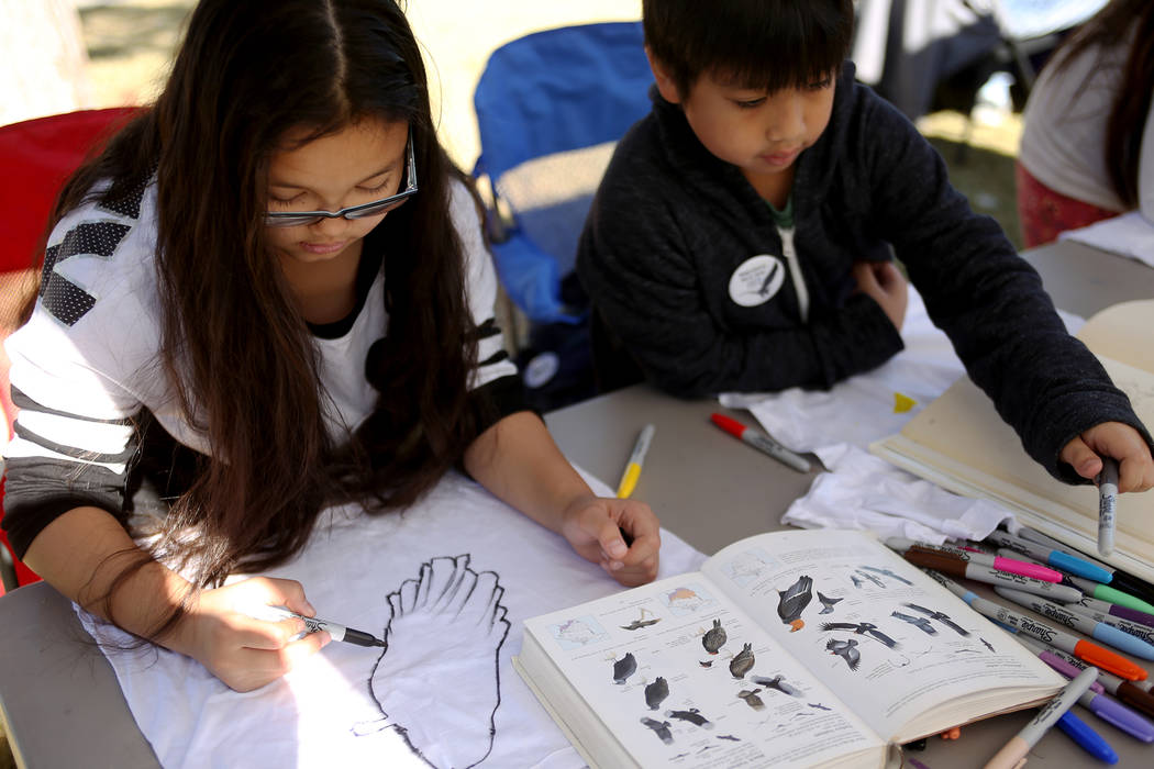 Layna Umipig, 9, left, and her brother Liam Umipig, 8, draw birds on t-shirts at Migratory Bird Day at Sunset Park in Las Vegas, Sunday, Nov. 18, 2018. Different organizations offered activities f ...