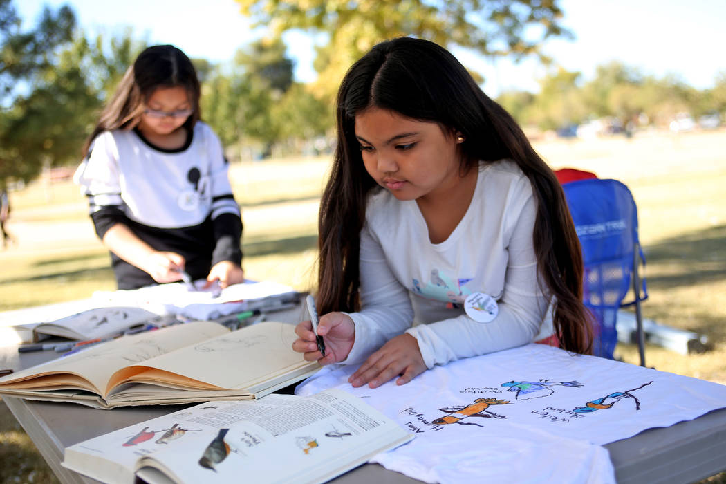 Zelliyah Nato, 7, draws birds on a t-shirt at a booth at Migratory Bird Day at Sunset Park in Las Vegas, Sunday, Nov. 18, 2018. Different organizations offered activities for kids and adults to le ...