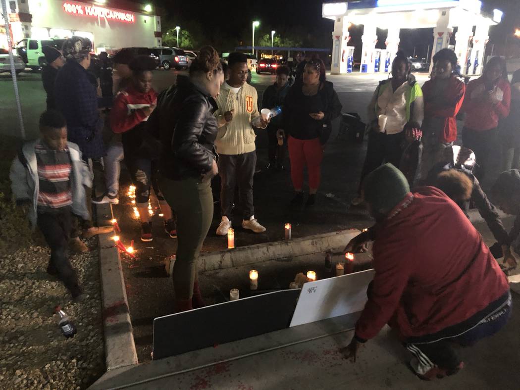 Sydney Harris, 33, stands closest to the front of posters remembering her son, 16-year-old LaMadre Harris, after a vigil Nov. 14. The 16-year-old boy died after a shooting in North Las Vegas on Tu ...