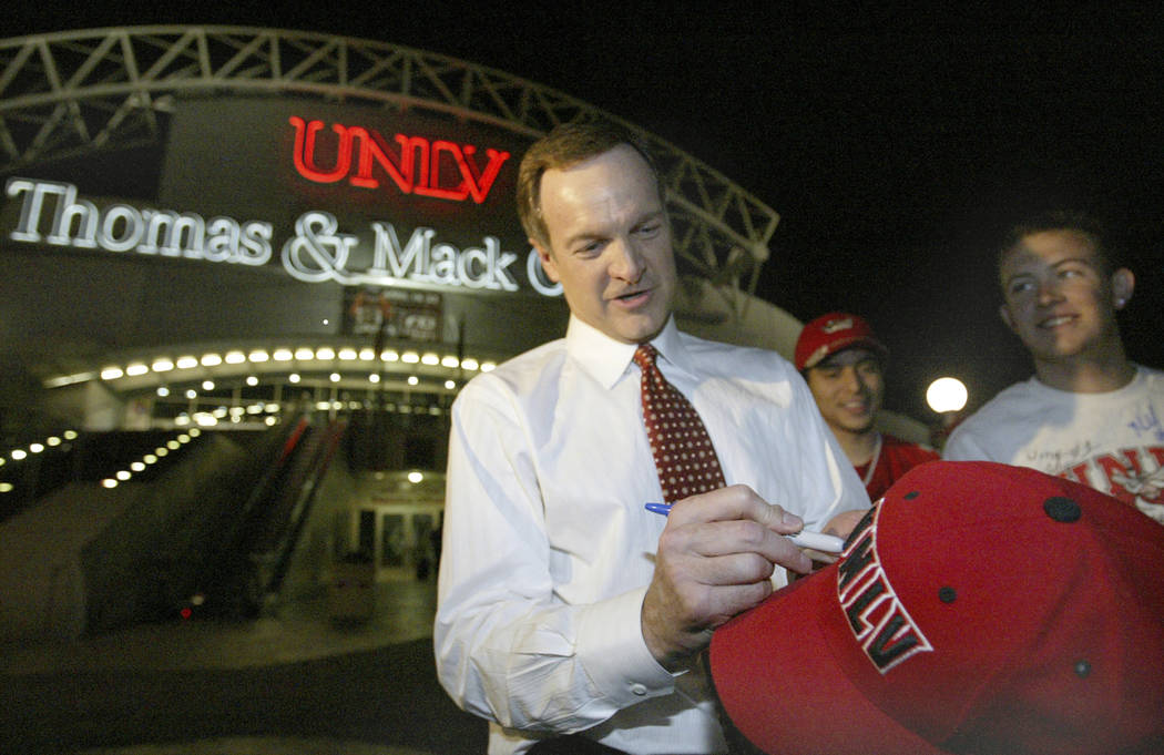 UNLV head basketball coach Lon Kruger signs a hat for a Runnin' Rebel fan outside the Thomas & Mack Center after the team returned from the opening rounds of the NCAA Men's Division I Basketba ...