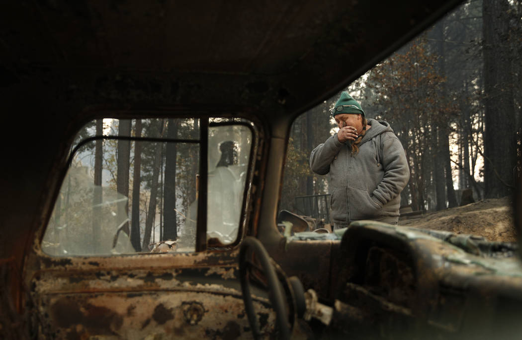 In this Nov. 15, 2018, photo, Troy Miller wipes his eyes as he walks beside a burned out car on his property in Concow, Calif. Miller said he tried to evacuate when the Camp Fire came roaring thro ...