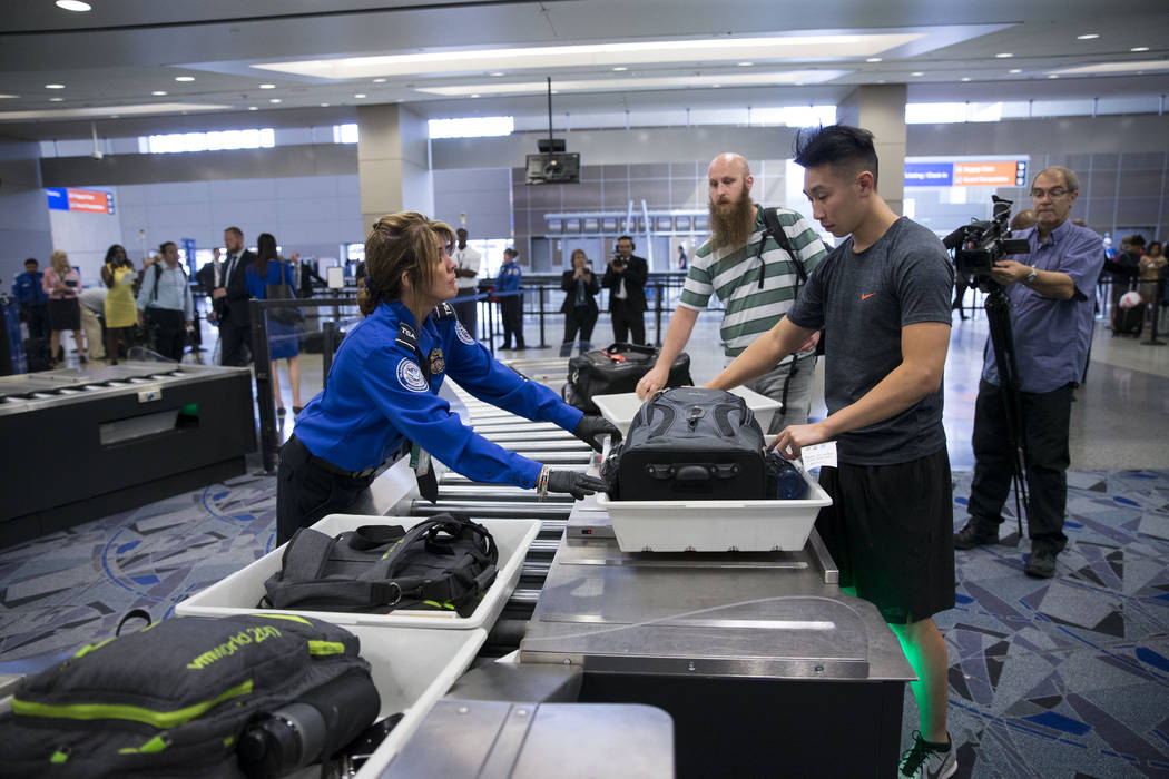 Transportation Security Administration agent Donna Franco, left, assists a passenger in one of the new automated screening lanes at McCarran International Airport Terminal 1 in Las Vegas, on Thurs ...