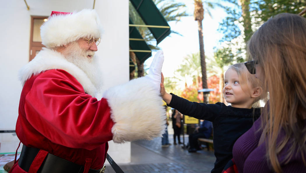 Santa Claus high-fives Henderson resident Emilia Brodie, 2, along with mother Monica Brodie at the District at Green Valley Ranch in Henderson, Saturday, Nov. 24, 2018. Caroline Brehman/Las Vegas ...