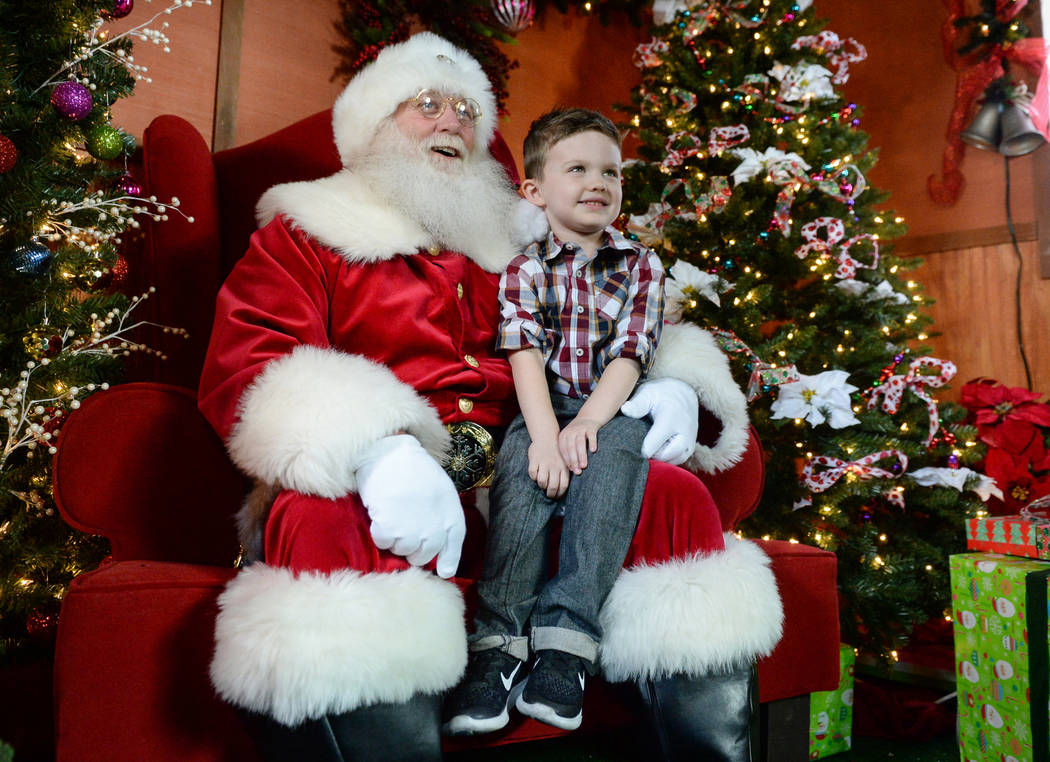 Maverick Willis, 5, from Henderson, sits on Santa Claus's lap, as they take a photograph together at the District at Green Valley Ranch in Henderson, Saturday, Nov. 24, 2018. Caroline Brehman/Las ...