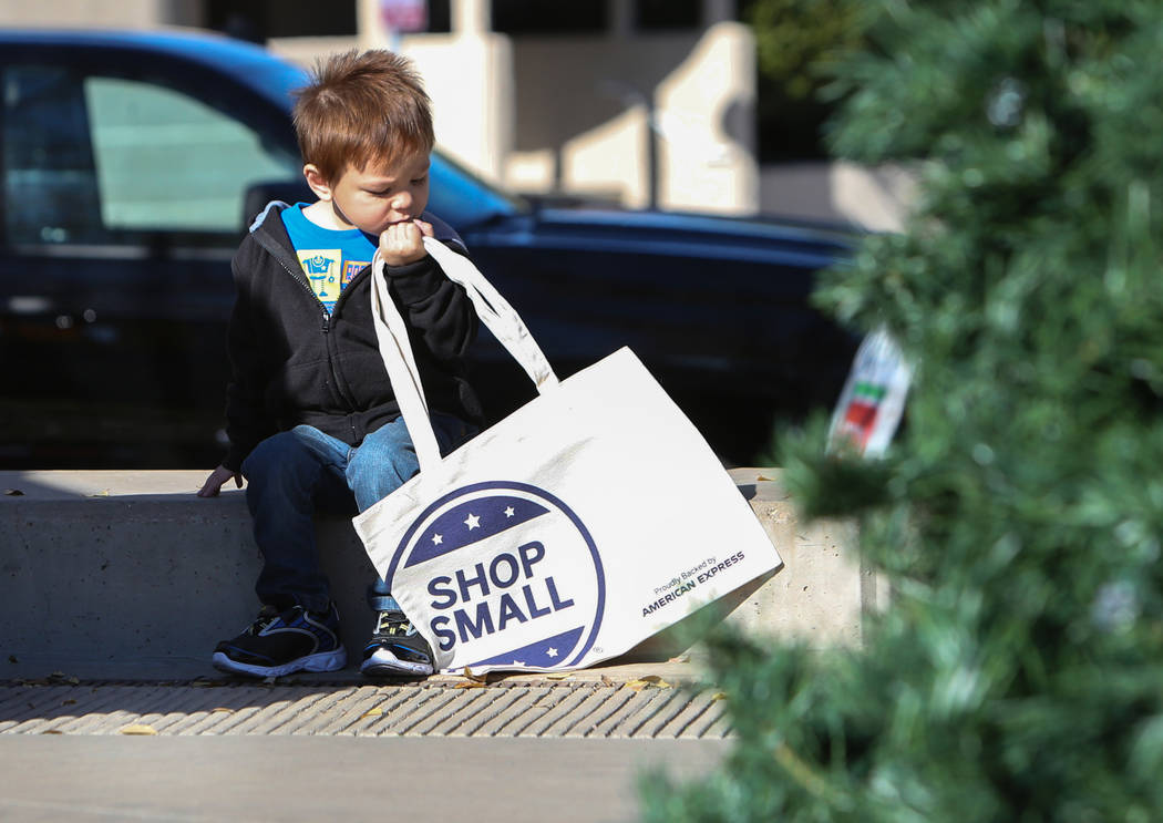Las Vegas resident Gabriel McGinnis, 3, looks down at a shop small tote bag being given out to attendees during Shop Small Henderson in Henderson, Saturday, Nov. 24, 2018. Caroline Brehman/Las Veg ...