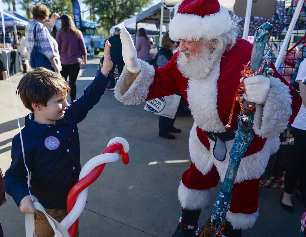 Henderson resident Luke Sisk, 5, goes to high five Bud Slade, dressed up as Santa Claus, during Shop Small Henderson in Henderson, Saturday, Nov. 24, 2018. Caroline Brehman/Las Vegas Review-Journal