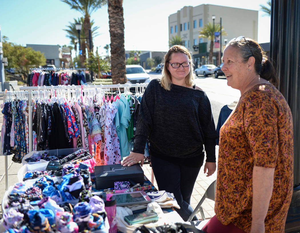 Daughter and mother Caitlin Krzisnik, left, and Diane Krzisnik, owners of Doodlebug Boutique, stand at a table set up along Water Street to sell items from their business during Shop Small Henders ...