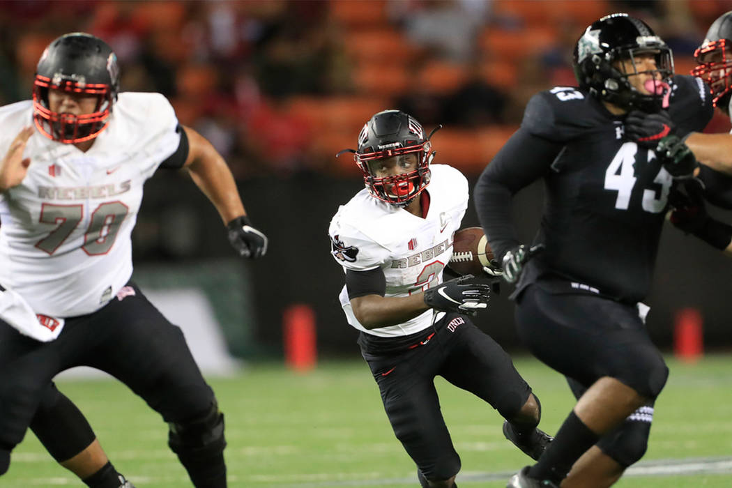 UNLV running back Lexington Thomas (3) breaks through the Hawaii defensive line during the first quarter of an NCAA college football game, Saturday, Nov. 17, 2018, in Honolulu. (AP Photo/Marco Garcia)