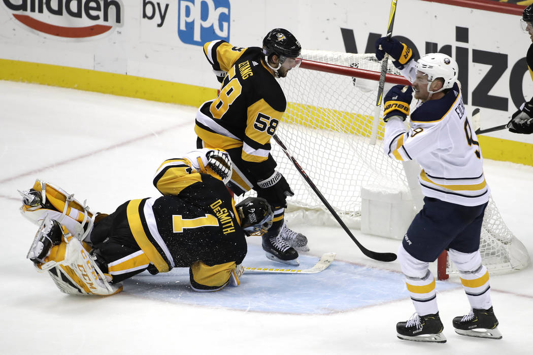 Buffalo Sabres' Jack Eichel (9) celebrates his game-winning overtime goal past Pittsburgh Penguins goaltender Casey DeSmith (1) with Kris Letang (58) defending during an NHL hockey game against th ...