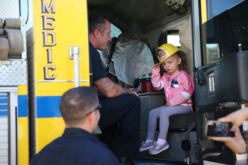 Scarlett Mize, 3, sits inside a fire engine with Clark County Fire Department firefighter Jonathan McBreen during a fire awareness visit to Merryhill Preschool, 5055 S. Durango Dr., in Las Vegas, ...