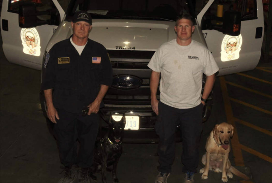 Dog handlers pose with Kya, left, and Dexter, right. (Clark County Fire Department)