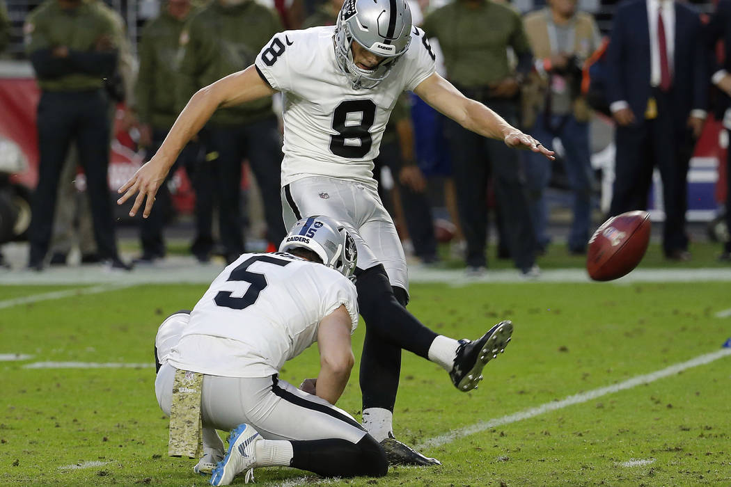 Oakland Raiders kicker Daniel Carlson (8) kicks the game winning field goal as punter Johnny Townsend (5) holds during the second half of an NFL football game against the Arizona Cardinals, Sunday ...