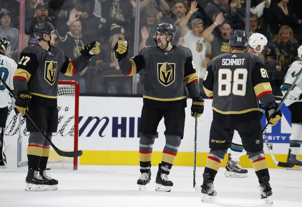 Vegas Golden Knights defenseman Shea Theodore, left, celebrates after right wing Alex Tuch, center, scored against the San Jose Sharks during the third period of an NHL hockey game Saturday, Nov. ...