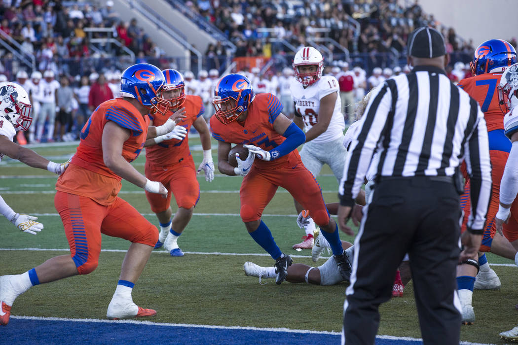 Bishop Gorman running back Amod Cianelli (23) breaks through Liberty defenders for a touchdown during the second half of the NIAA 4A Desert Region championship game at Bishop Gorman High School in ...