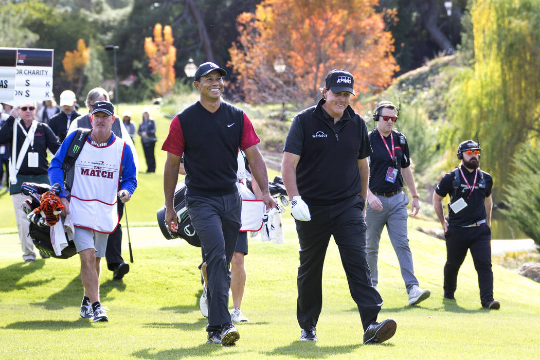 Tiger Woods, left, and Phil Mickelson walk to the fairway after teeing off from the first during The Match at Shadow Creek Golf Course in North Las Vegas on Friday, Nov. 23, 2018. Richard Brian La ...
