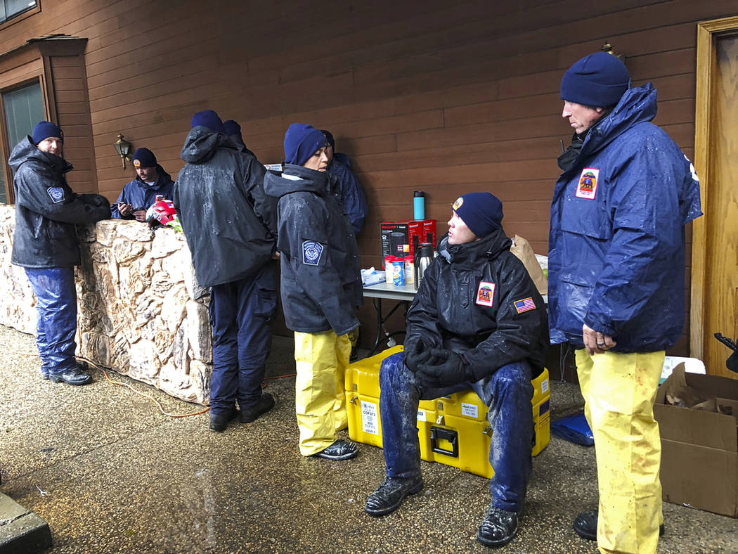 National Urban Search & Rescue Response System Orange County CATF-5 team members Imelda Cordova, third from right, talks to Andrew Ricker and Chris Stevens, far right, as their team takes cover fr ...