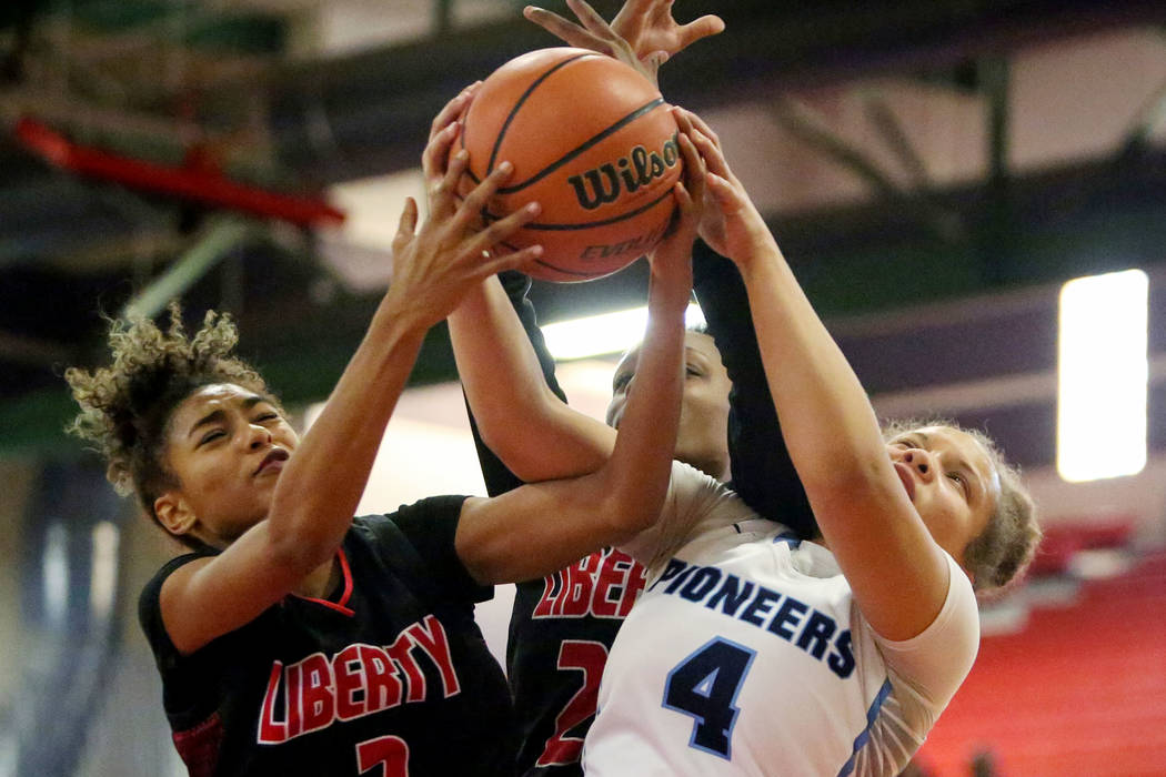 Liberty's Journie Augmon (3) and Olivia Children (23) fight for the ball against Canyon Spring's Jhane Richardson (4) during the first half of the Championship game of the Liberty Thanksgiving Inv ...