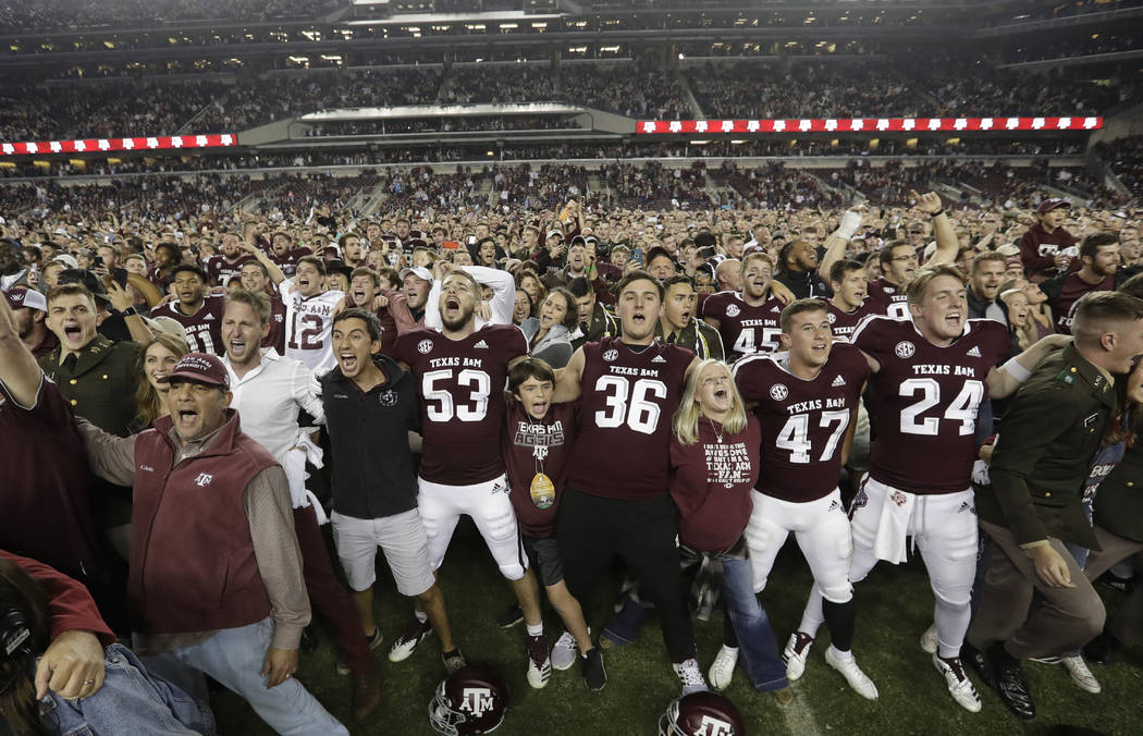 Fans and students join Texas A&M football players on the field after an NCAA college football game against LSU Saturday, Nov. 24, 2018, in College Station, Texas. Texas A&M won 74-72 in se ...