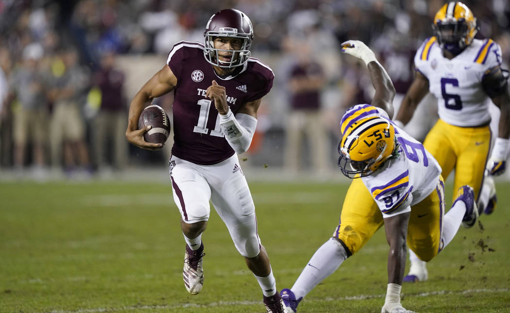 Texas A&M quarterback Kellen Mond (11) breaks away from LSU defensive end Glen Logan (97) during the first half of an NCAA college football game Saturday, Nov. 24, 2018, in College Station, Te ...