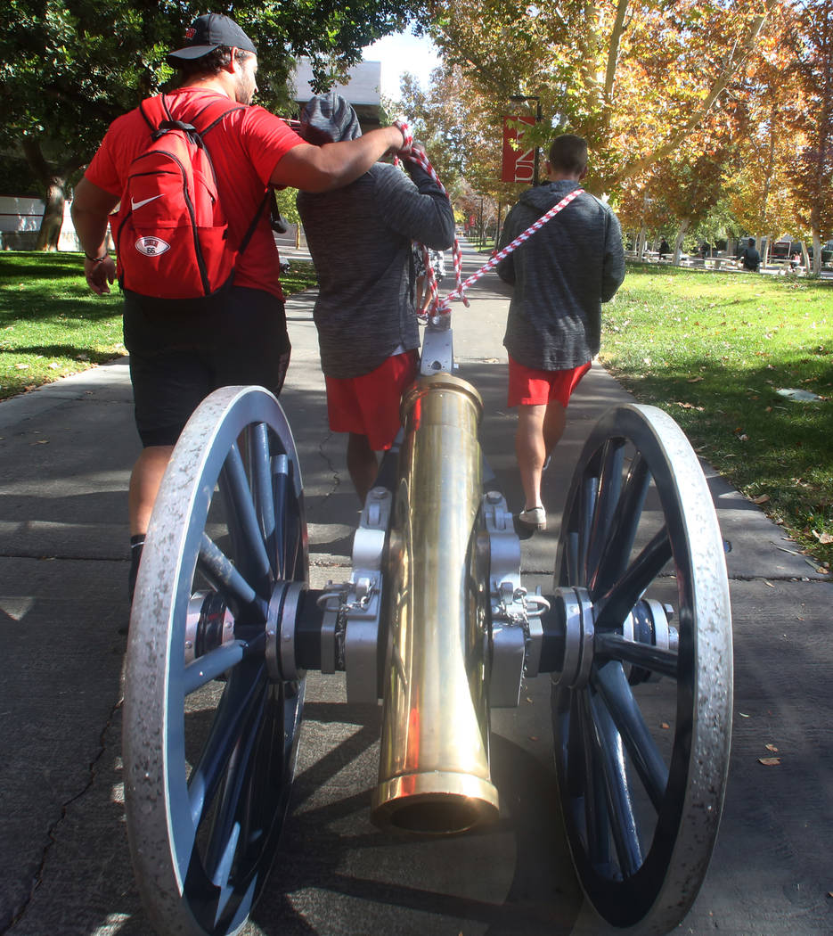 UNLV football players, including kicker Evan Pantels, right, pull the Fremont Cannon to be painted red outside of the Student Union at UNLV on Monday, Nov, 26, 2019, in celebration of their victo ...