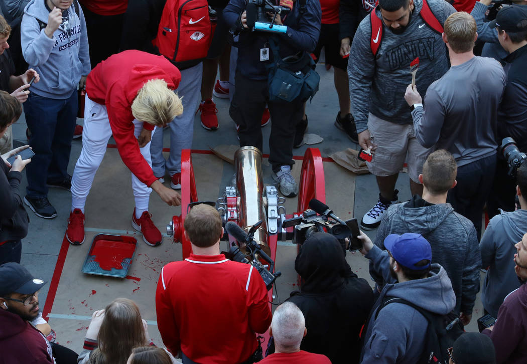 UNLV students and officials watch as Rebels players paint the Fremont Cannon red outside of the Student Union at UNLV on Monday, Nov, 26, 2019, in celebration of their victory against in-state riv ...