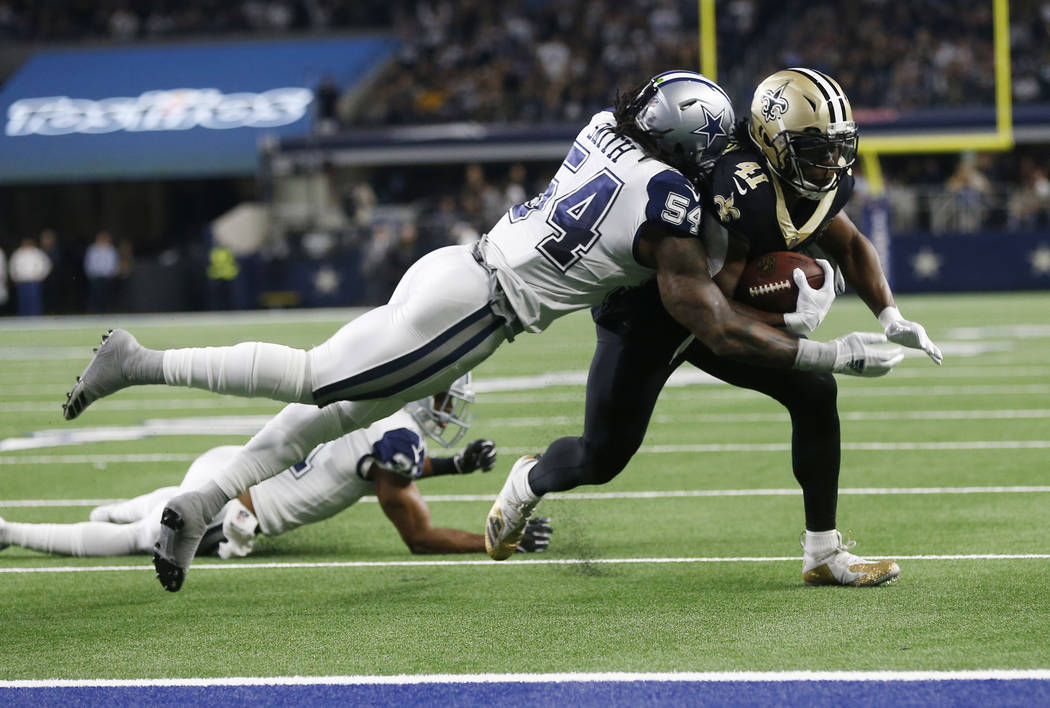 New Orleans Saints running back Alvin Kamara (41) is hit by Dallas Cowboys middle linebacker Jaylon Smith (54) and stopped short of the goal line in the first half of an NFL football game, in Arli ...