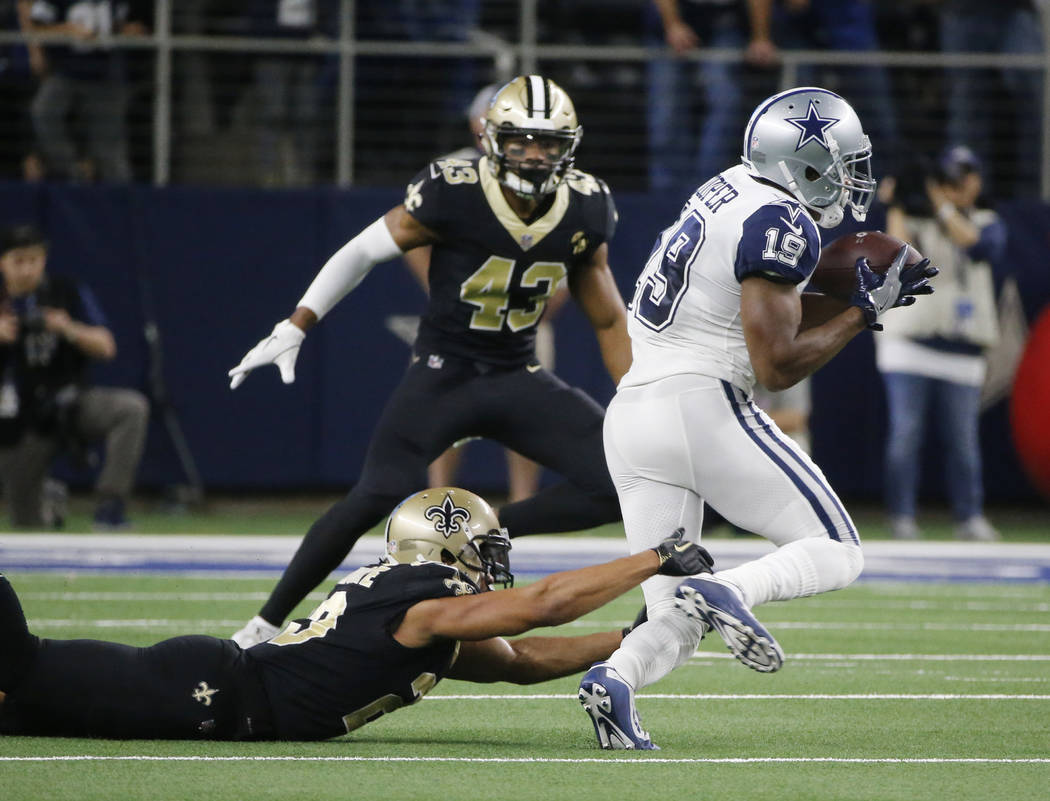 Dallas Cowboys wide receiver Amari Cooper (19) pull in a pass over New Orleans Saints cornerback Marshon Lattimore (23) in the first half of an NFL football game, in Arlington, Texas, Thursday, No ...