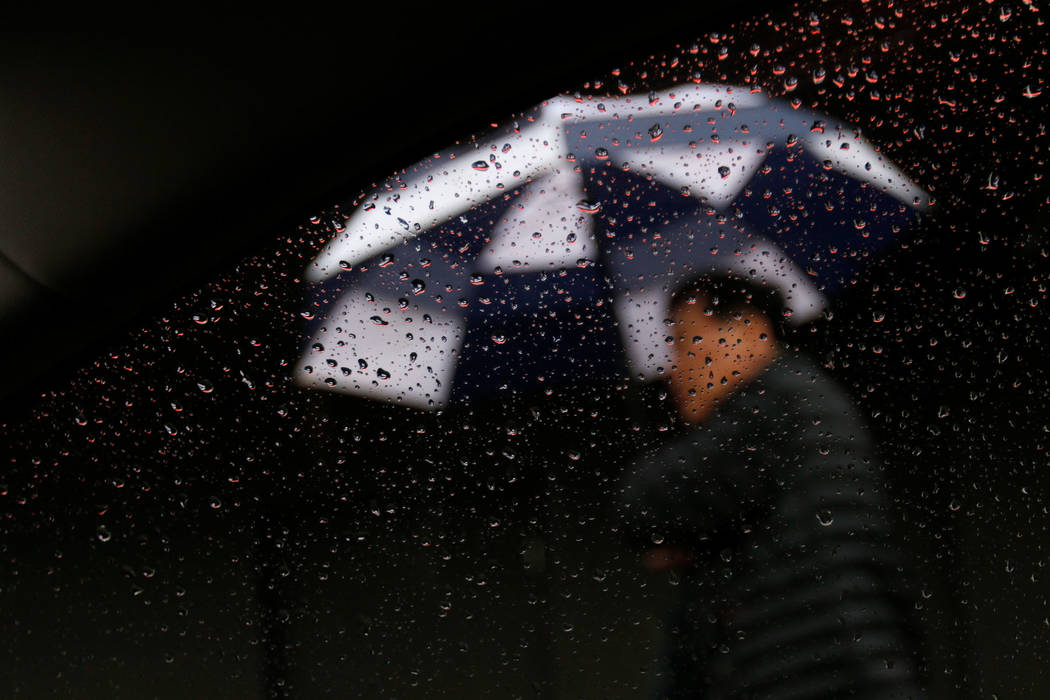 A pedestrian walks with his umbrella in the rain on Fremont Street in Las Vegas, Thursday, Nov. 29, 2018. Chitose Suzuki Las Vegas Review-Journal @chitosephoto
