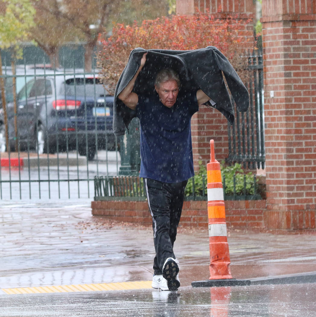 A man crosses Main Street a rainstorm on Thursday, Nov. 29, 2019, in Las Vegas. Bizuayehu Tesfaye Las Vegas Review-Journal @bizutesfaye