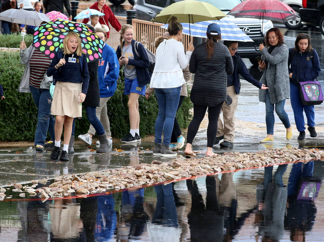 Students and parents at St. Viator School avoid a flooded sidewalk as they walk near Eastern Avenue on Thursday, Nov. 29, 2019, in Las Vegas. Bizuayehu Tesfaye Las Vegas Review-Journal @bizutesfaye