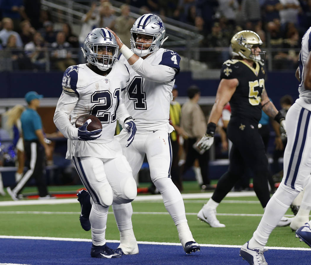 Dallas Cowboys running back Ezekiel Elliott (21) celebrates his touchdown against the New Orleans Saints with quarterback Dak Prescott (4) in the first half of an NFL football game, in Arlington, ...