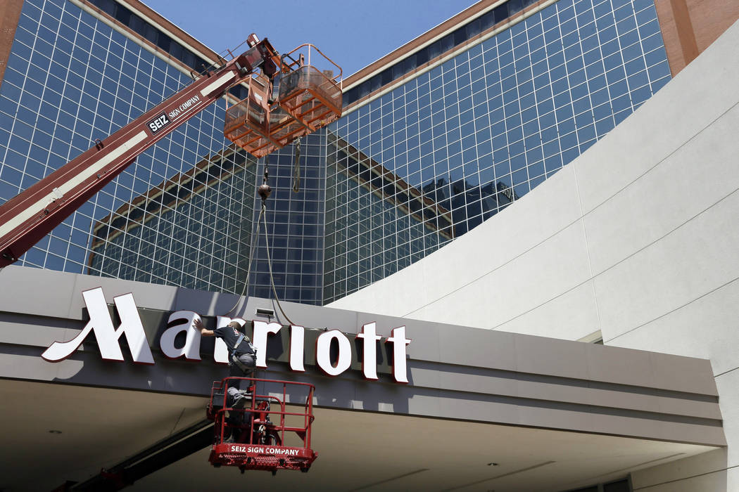 In this Tuesday, April 30, 2013, file photo, a man works on a new Marriott sign in front of the former Peabody Hotel in Little Rock, Ark. (AP)