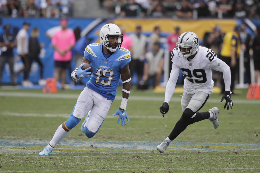 Los Angeles Chargers wide receiver Keenan Allen carries the ball past Oakland Raiders defensive back Leon Hall during an NFL football game Sunday, Oct. 7, 2018, in Carson, Calif. (AP Photo/Jae C. ...
