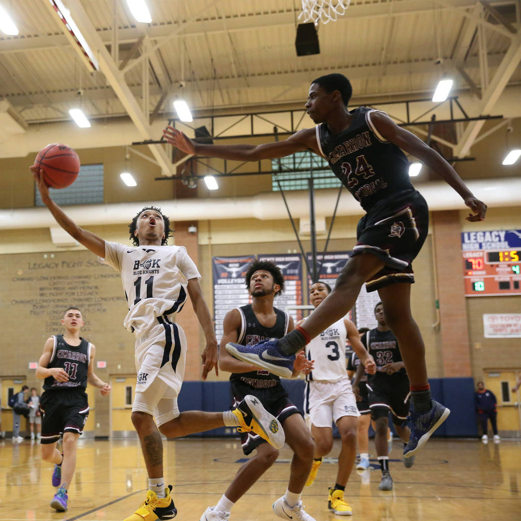 Democracy Prep's Justous Harvey (11) goes up for a shot against Cimarron-Memorial's Malik Kennedy (24) in their basketball game at Legacy High School in North Las Vegas, Friday, Nov. 30, 2018. Eri ...